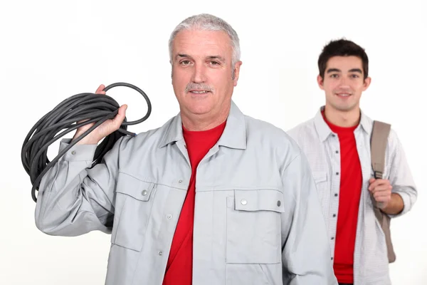 Um comerciante experiente posando com seu novo aprendiz — Fotografia de Stock