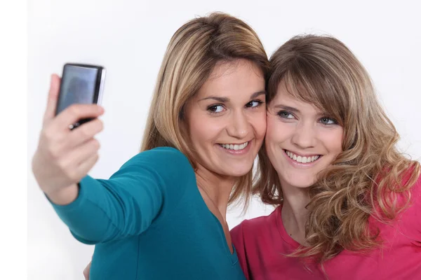 Duas meninas tirando uma foto com um telefone celular — Fotografia de Stock
