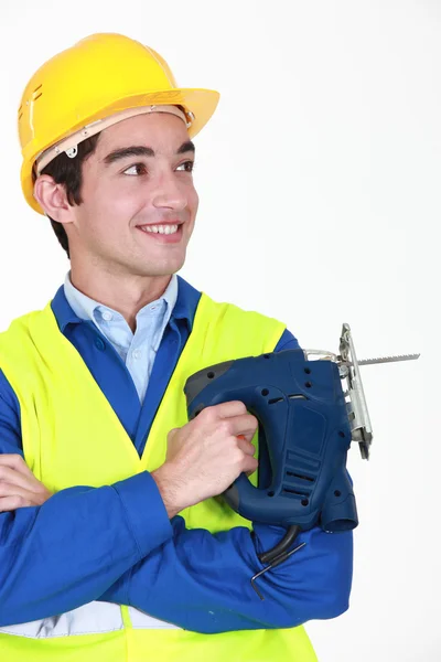 Smiling worker with an electric jigsaw — Stock Photo, Image