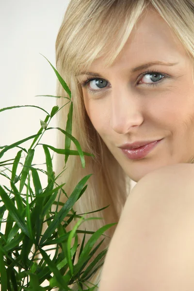 Portrait of blond holding green plant leaf — Stock Photo, Image