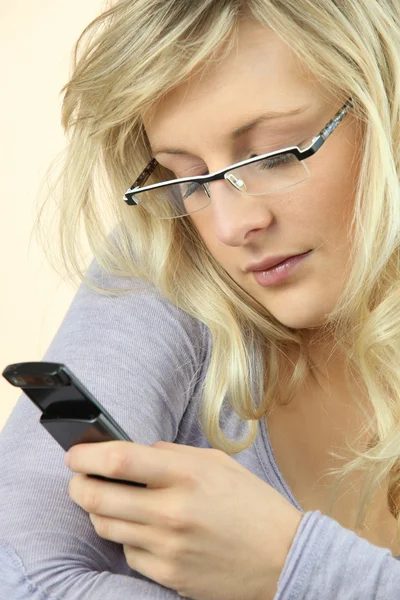 Mujer con gafas enviando un mensaje de texto — Stockfoto