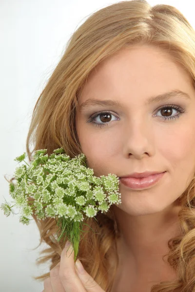 Portrait of a young woman holding flowers — Stock Photo, Image