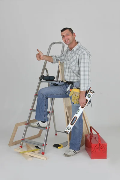 Carpenter stood by ladder giving the thumbs-up — Stock Photo, Image