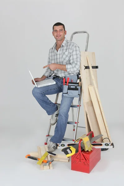 Bir dizüstü bilgisayar ile bir marangoz — Stok fotoğraf