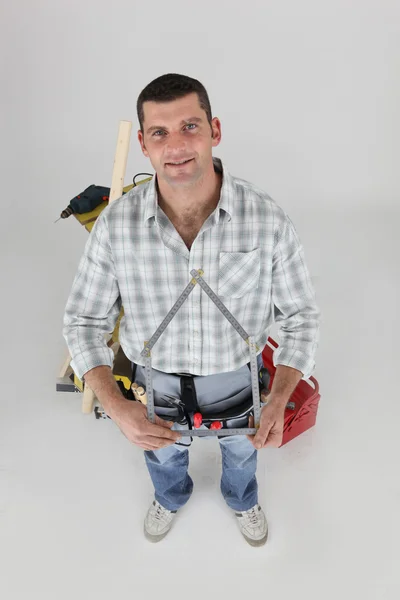 Hombre sosteniendo casa en forma de dispositivo de medición —  Fotos de Stock