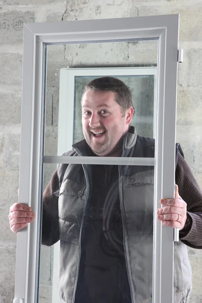 Happy contractor carrying PVC window — Stock Photo, Image