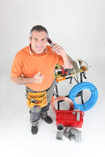 Full-length portrait of experienced craftsman making a call Stock Picture
