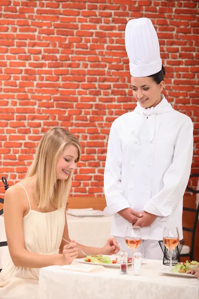 Νεαρή γυναίκα συγχαίροντας τον θηλυκό σεφ στο εστιατόριο — Φωτογραφία Αρχείου