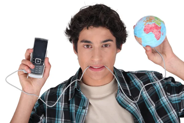 Young man with his cellphone plugged into the world — Stock Photo, Image