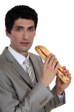 Businessman eating a sandwich clipart