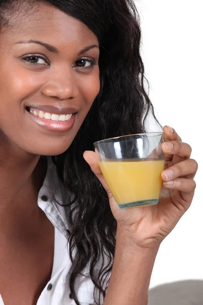 Wunderschöne schwarze Frau trinkt Orangensaft — Stockfoto