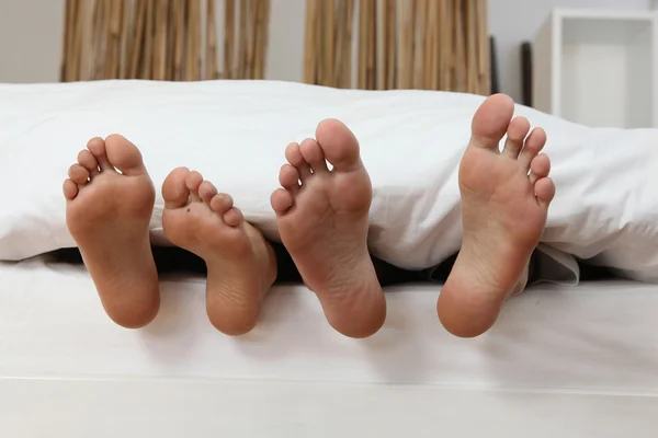 Male and female feet in bed — Stock Photo, Image