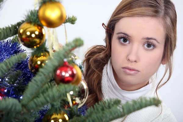Woman posing next to a Christmas tree Stock Picture