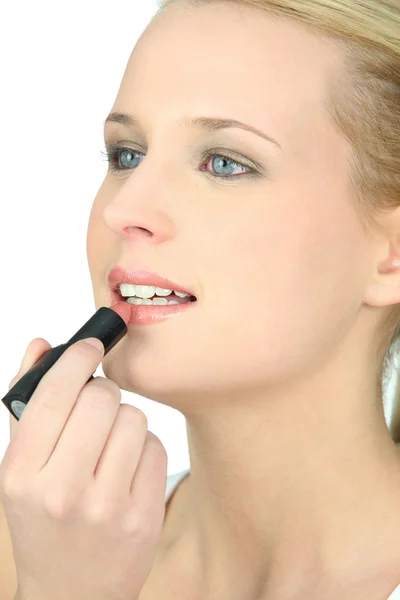 Woman applying lipstick Stock Image
