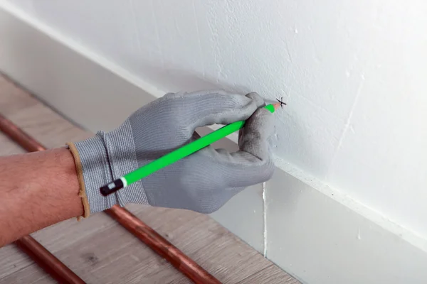 Trabajador con guante dibujo hito en una pared —  Fotos de Stock