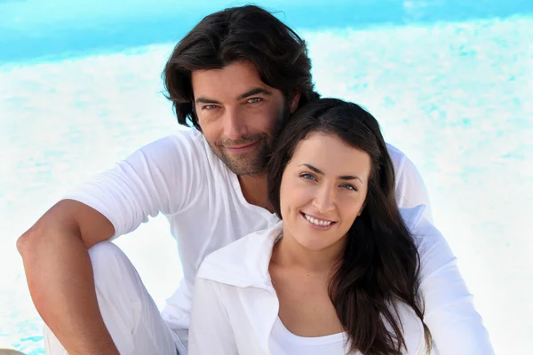 Couple sitting by a pool — Stock Photo, Image