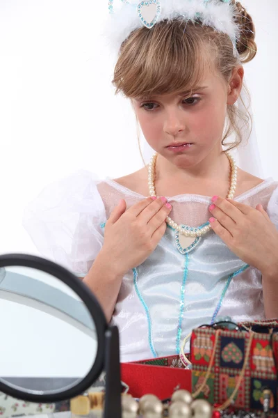 Menina vestida como uma princesa tentando colar — Fotografia de Stock