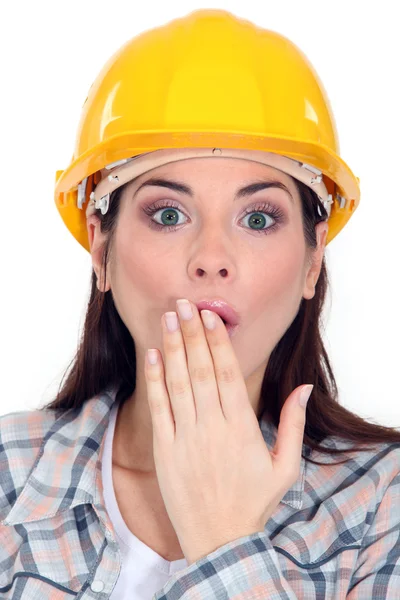 Schockierte Bauarbeiterin deckt Mund zu — Stockfoto