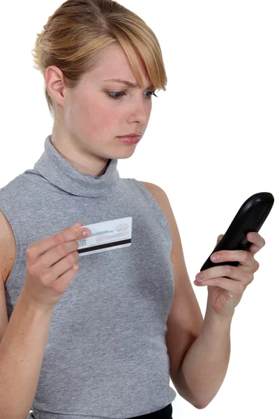 Woman using a phone card Royalty Free Stock Images