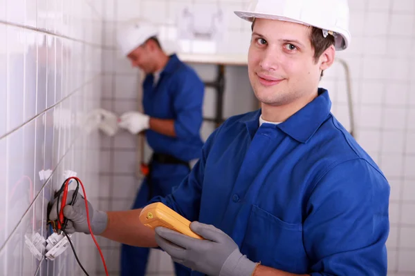Electricista joven usando un voltímetro — Foto de Stock