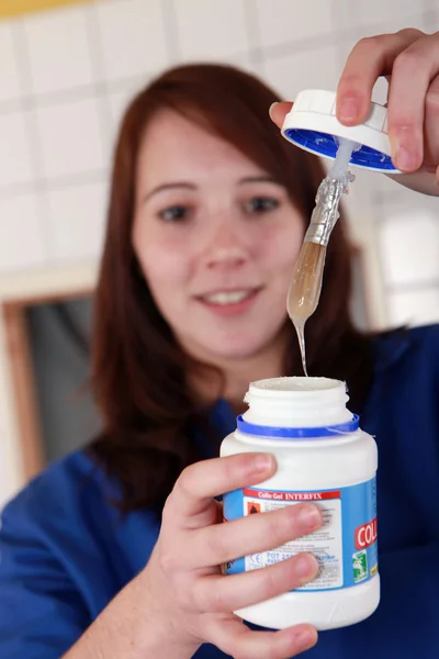 Obrero joven con una olla de pegamento — Foto de Stock