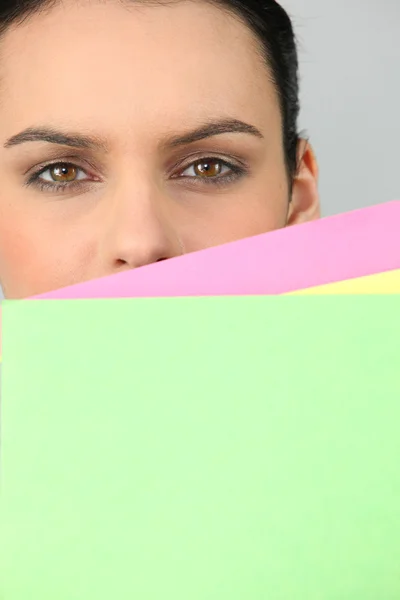 Mujer escondiendo la cara detrás de documentos — Foto de Stock