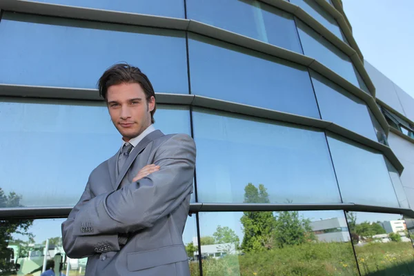 Jeune homme d'affaires debout devant un immeuble — Photo