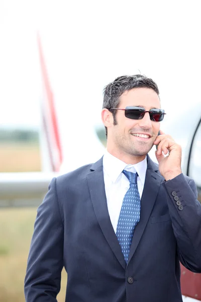 Cavalheiro sorridente de pé ao lado de uma aeronave leve — Fotografia de Stock