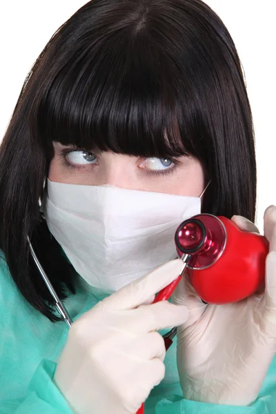 Doctor listening to the heartbeat of a heart — Stock Photo, Image