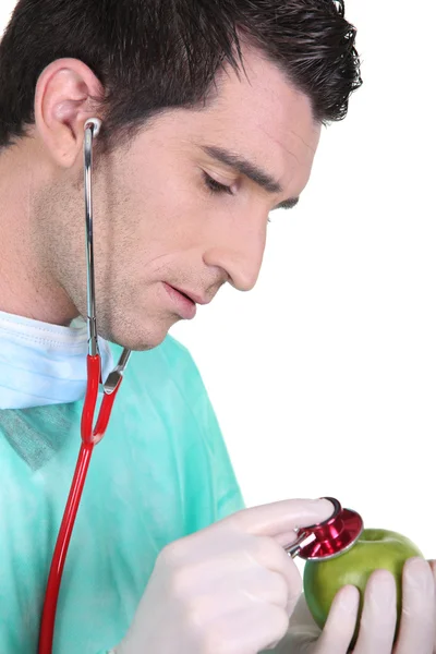Medico che utilizza lo stetoscopio su una mela — Foto Stock