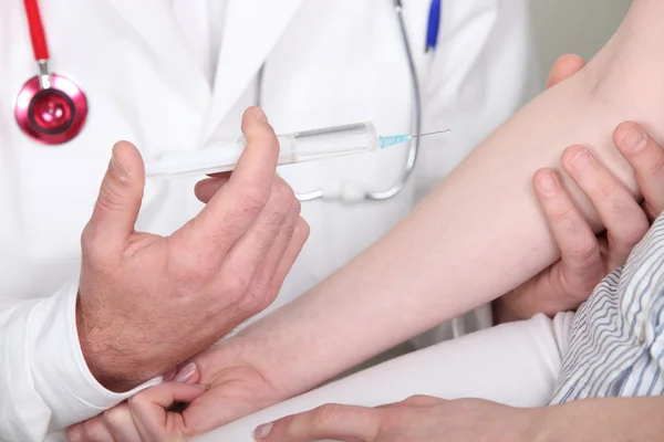 Doctor jabbing patient with syringe — Stock Photo, Image