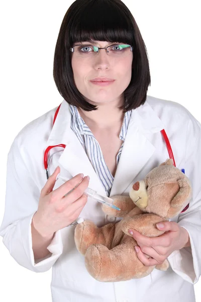 Жінка-лікар впорскує плюшевого ведмедя — стокове фото