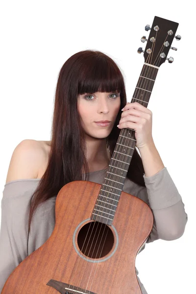 Mujer joven sosteniendo una guitarra — Foto de Stock