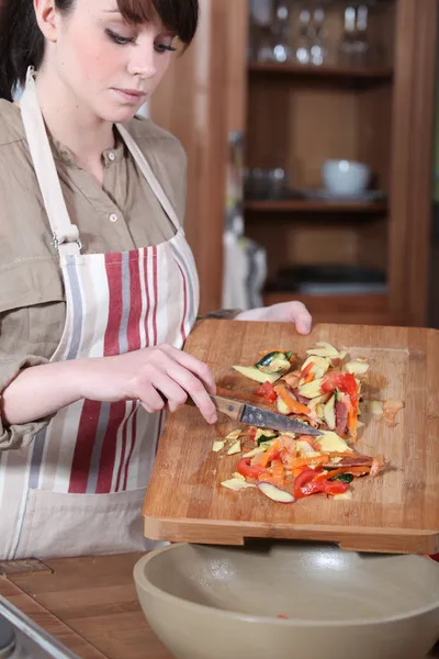 Jovem mulher coleta de vegetais peelings — Fotografia de Stock