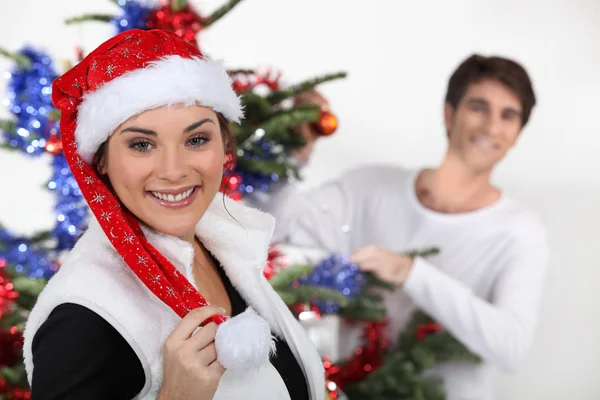 Couple decorating a Christmas tree Royalty Free Stock Photos