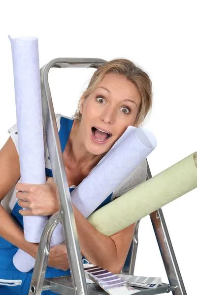 Happy woman with rolls of wallpaper — Stock Photo, Image