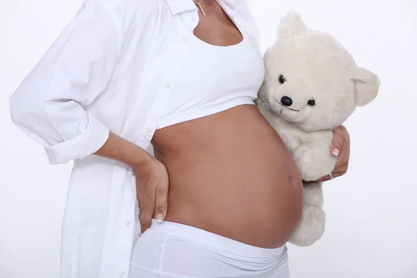 Embarazada vientre con peluche oso — Foto de Stock