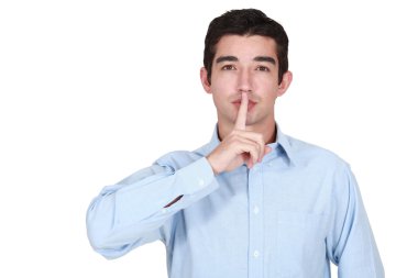 Young man holds finger before lips clipart