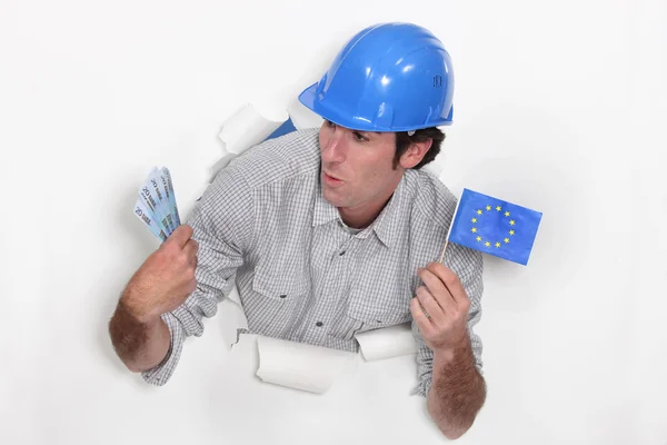 Tradesman holding a European Union flag and money — Stock Photo, Image