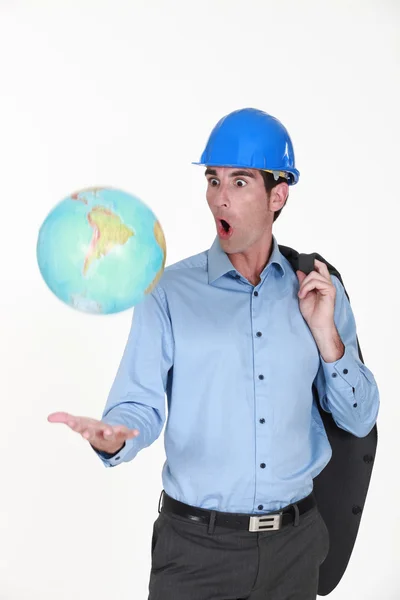 Ingenieur opgooien van een wereldbol — Stockfoto