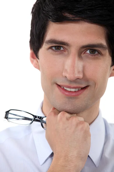 Retrato de cerca de un hombre sonriente sosteniendo sus gafas — Foto de Stock