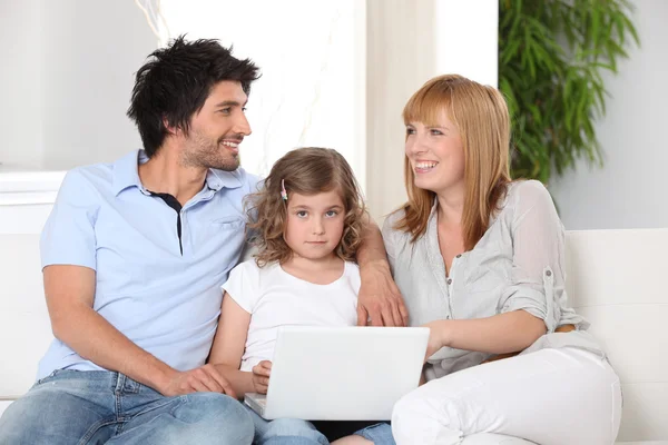 Los padres y la hija usando una computadora portátil — Foto de Stock