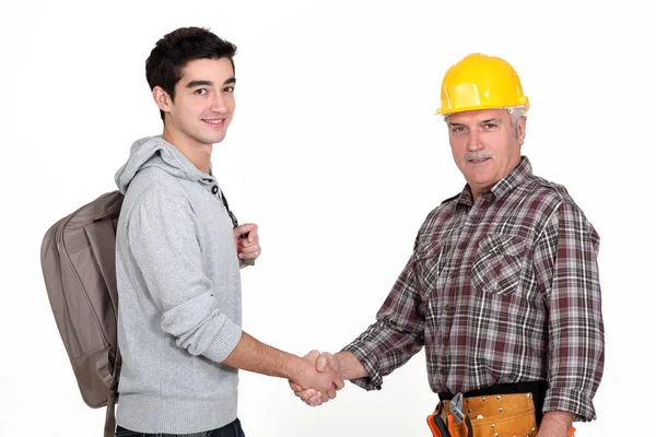 Construction worker shaking hands with a college student Royalty Free Stock Images