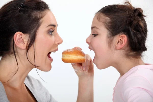 Mulher e irmãzinha lutando por fritter — Fotografia de Stock