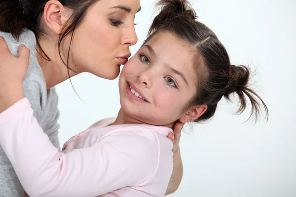 Frau küsst süßes kleines Mädchen — Stockfoto