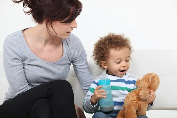 Kvinna och barn med en nallebjörn — Stockfoto