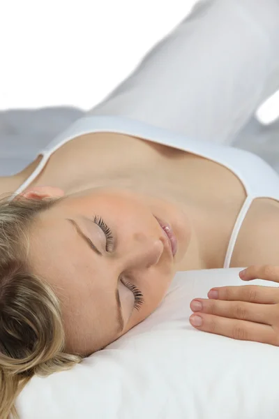 Mulher em branco dormindo em uma cama branca — Fotografia de Stock