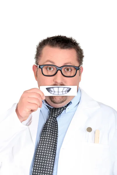 Мужчина-дантист держит фотографию зубов — стоковое фото