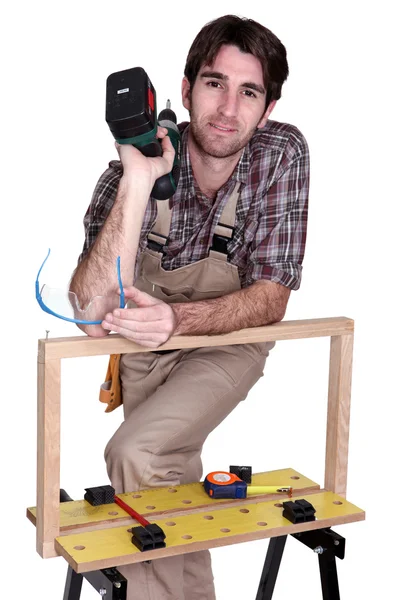 Onun tezgah ile poz ve elektrikli tornavida tutan adam — Stok fotoğraf