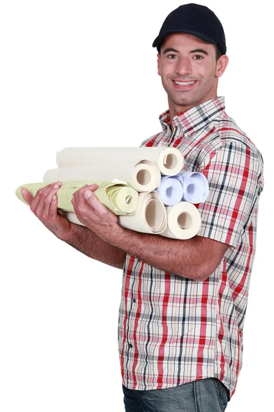 Hombre llevando rollos de papel pintado — Foto de Stock